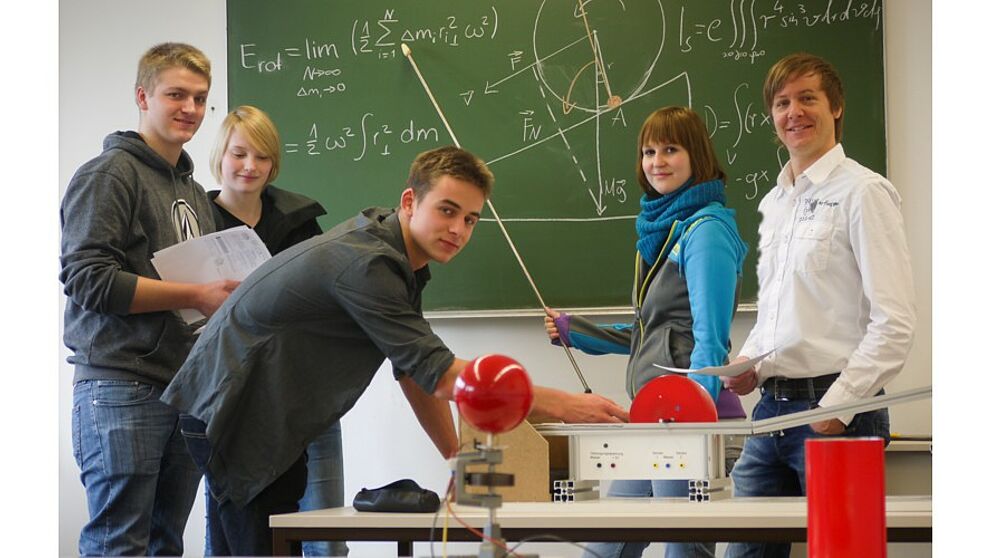 Foto (Department Physik): Physik-Studierende und Dr. Marc Sacher, Studienberater und Leiter des Physikalischen Grundpraktikums, gemeinsam im Labor.