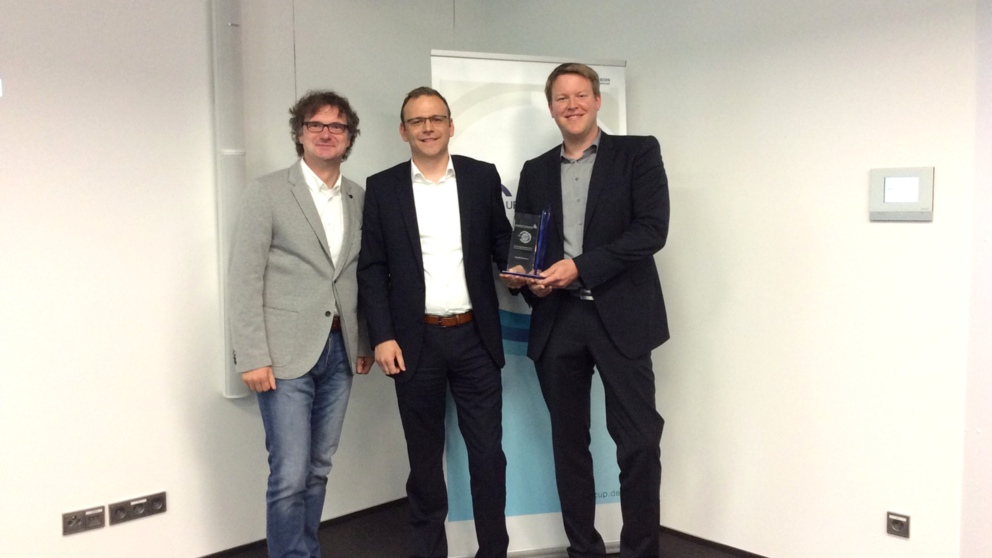 Foto (Universität Paderborn, TecUP): Prof. Dr. Rüdiger Kabst zeichnet die jungen Gründer Dr. Ben-jamin Nagel und Dr. Fabian Christ aus (v. l. n. r.).