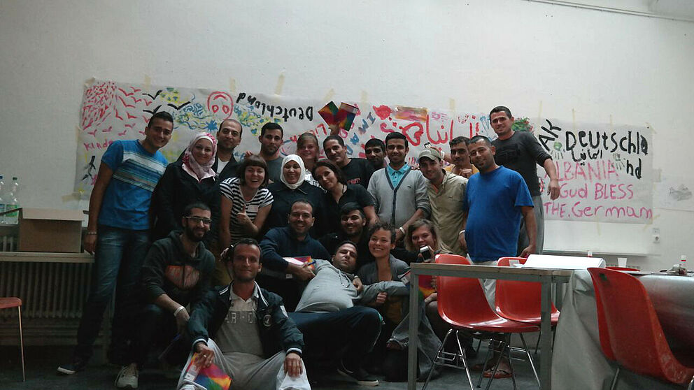 Foto (Universität Paderborn, Fach Kunst): Gruppenbild mit einigen Flüchtlingen und Helferinnen.