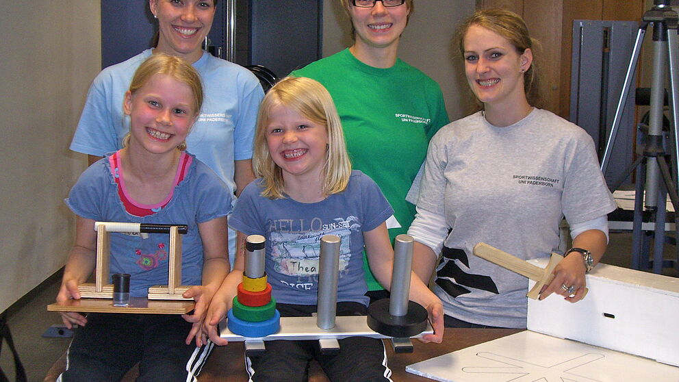 Foto (Universität Paderborn): Das „Greifstudien-Team“ (v. li.): Jacqueline Sievers und Vanessa Heitbreder, studentische Hilfskräfte und Kathrin Wunsch, Doktorandin und Leiterin der Studie, freuen sich mit zwei Teilnehmerinnen über einen gelungenen 