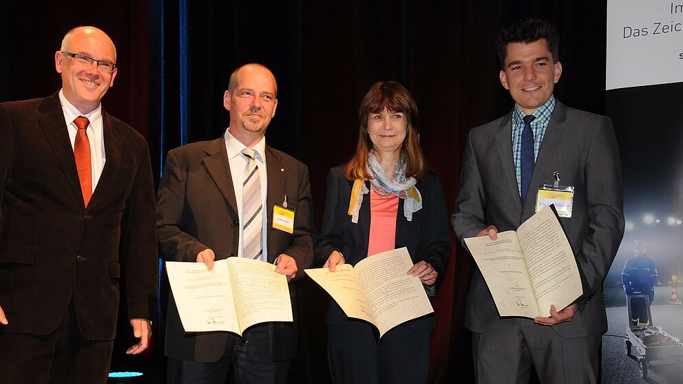 Foto (Friedrich Kulke, Feuerwehr Hamm): Dirk Aschenbrenner (Präsident der vfdb e. V.) zeichnete (v. l.) Dr. Michael Neske (Institut der Feuerwehr Sachsen-Anhalt), Sabina Kaczmarek (Berliner Feuerwehr), Dr.-Ing. Jens Pottebaum (Universität Paderborn) und