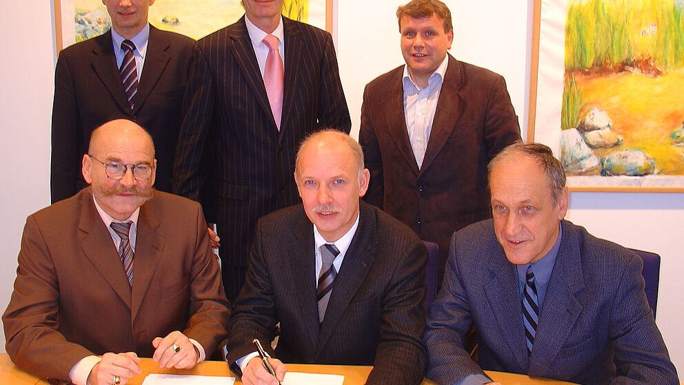 Foto (Universität Paderborn, Tibor Werner Szolnoki): Vertragsunterzeichnung im Präsidium der Universität Paderborn (vorn v. l.): Jürgen Plato, Dieter Herzog, Prof. Dr. Franz Josef Rammig; (hinten v. l.): Georg Müller, Prof. Dr. Nikolaus Risch, Bernha