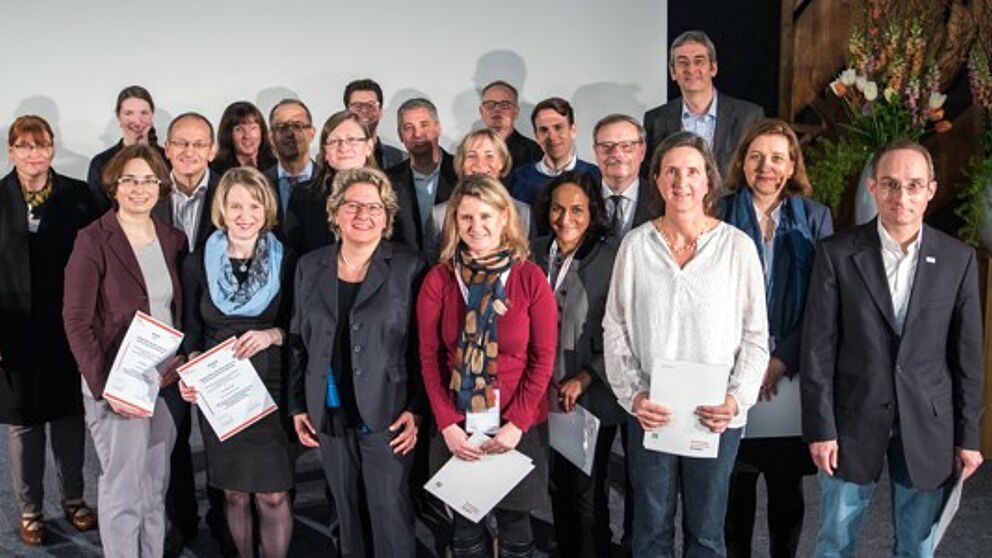 Foto (Costa Belibasakis/TH Köln): Preisübergabe in Anwesenheit von NRW-Wissenschaftsministerin Svenja Schulze, 1. Reihe, 3. von links, links daneben Juliane Fuge. 2. Reihe, 2. von links: Prof. Dr. Niclas Schaper (Vorstandsmitglied der dghd).