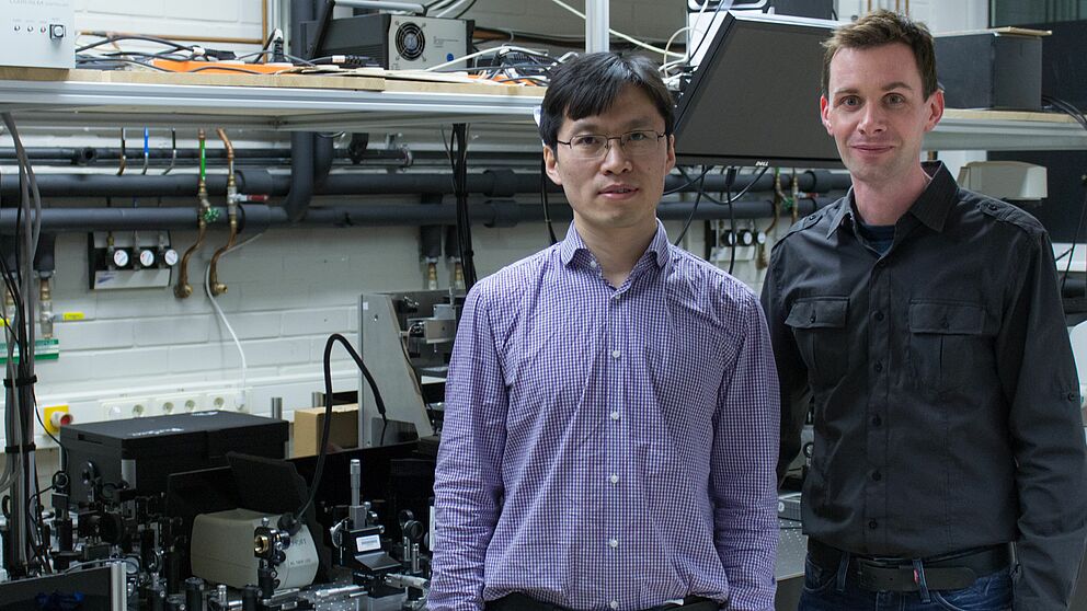 Bild (Department Physik): Dr. Guixin Li (links) und Prof. Thomas Zentgraf (rechts) im Laserlabor an der Universität Paderborn.