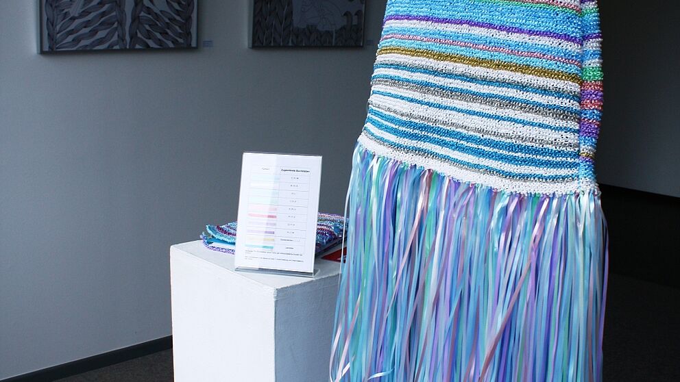 Foto (Frauke Döll): Das gestrickte Kleidobjekt von Anastasia Frühauf verschlüsselt einen Spruch mittels Farben und Reihen.