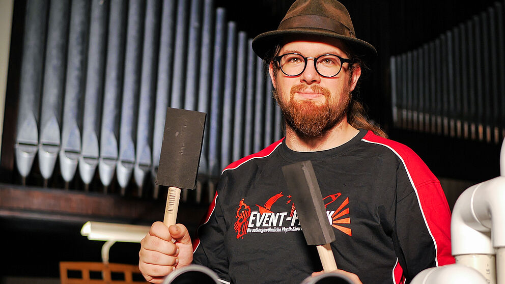 Foto (Universität Paderborn, Johannes Pauly): Event-Physiker Lucas Pauly mit den Sticks für seine verbesserte, komplett neu gebaute PVC-Orgel.