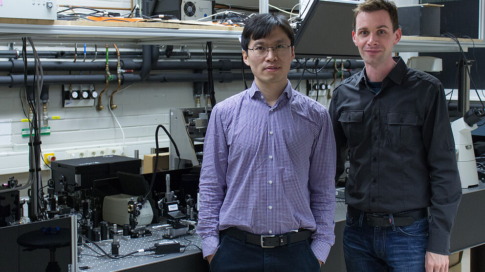 Bild (Department Physik): Dr. Guixin Li (links) und Prof. Thomas Zentgraf (rechts) im Laserlabor an der Universität Paderborn.