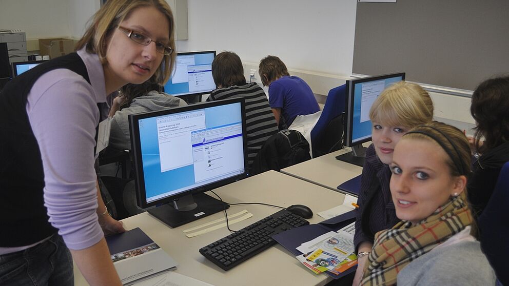 Foto (Mark Heinemann): Der Verschlüsselung auf der Spur: Stefanie Naewe aus dem Institut für Informatik mit Teilnehmerinnen des Schüler-Kryptotages.