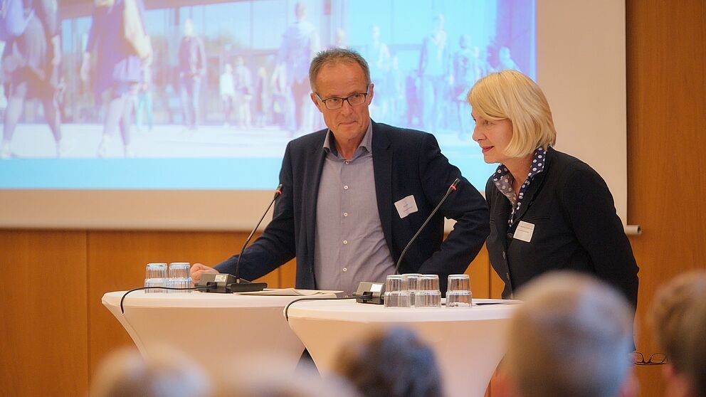 Foto (Arthur Isaak, Copyright: Hochschule OWL): Michael Uhlich (Bezirksregierung Detmold) (li.) und Professorin Ingeborg Schramm-Wölk (Vorsitzende Campus OWL/Präsidentin FH Bielefeld) begrüßen die Gäste der Jubiläumsveranstaltung.