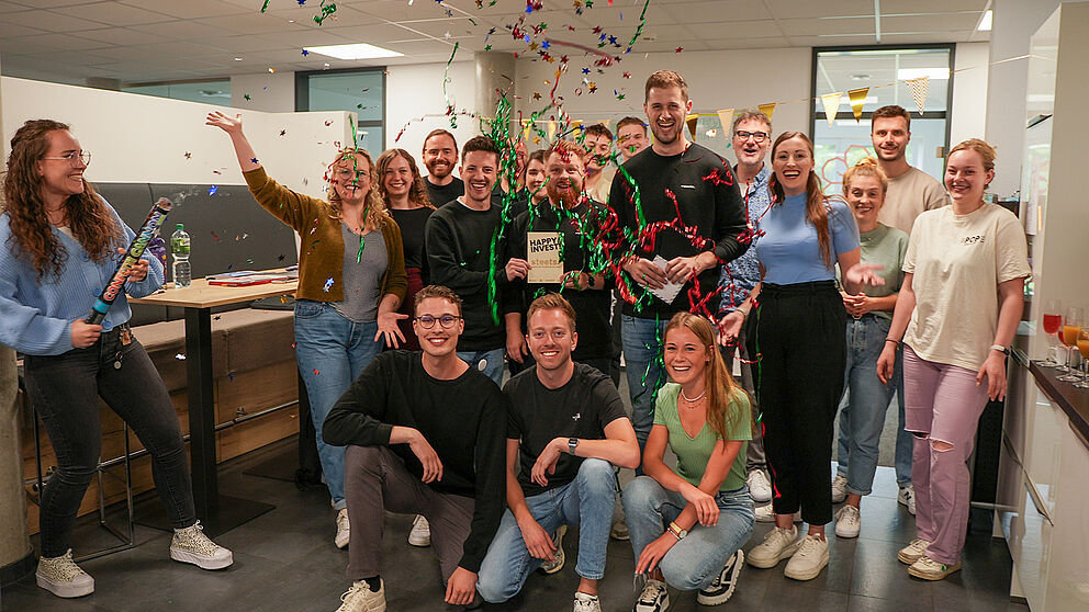 The garage33 team celebrates the investment in the start-up "Steets" together with the three founders by setting off a confetti cannon.
