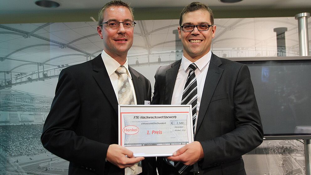 Foto (Universität Paderborn): Herr Kohlstrung (Henkel AG & Co. KGaA) überreicht den ersten Preis an Sven Bednorz (LWF, Uni Paderborn) für dessen herausragende Forschungsarbeit.