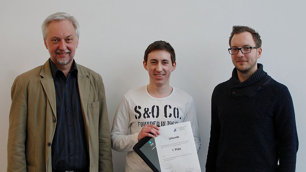 Abbildung: Prof. Wilhelm Schäfer und Organisator Matthias Becker übergeben den Preis an Christian Klaussner, Gewinner des „Coding Contest 2012“.