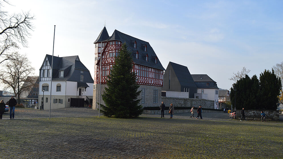 Abbildung: Beim Verlassen des Domes macht das „Diözesanzentrum St. Nikolaus“ mit markant-rotem Gebälk auf sich aufmerksam. In diesem Gebäudeteil, einem Fachwerkbau aus dem Jahre 1490, befand sich bis vor kurzem das Büro des Bischofs – Domblick i
