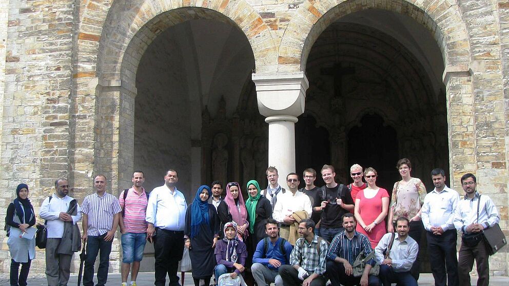 Foto (Universität Paderborn, Ann-Christin Baumann): Iranisch-libanesisch-deutsche Gruppe am 10. August vor dem Paradiesportal des Paderborner Doms.