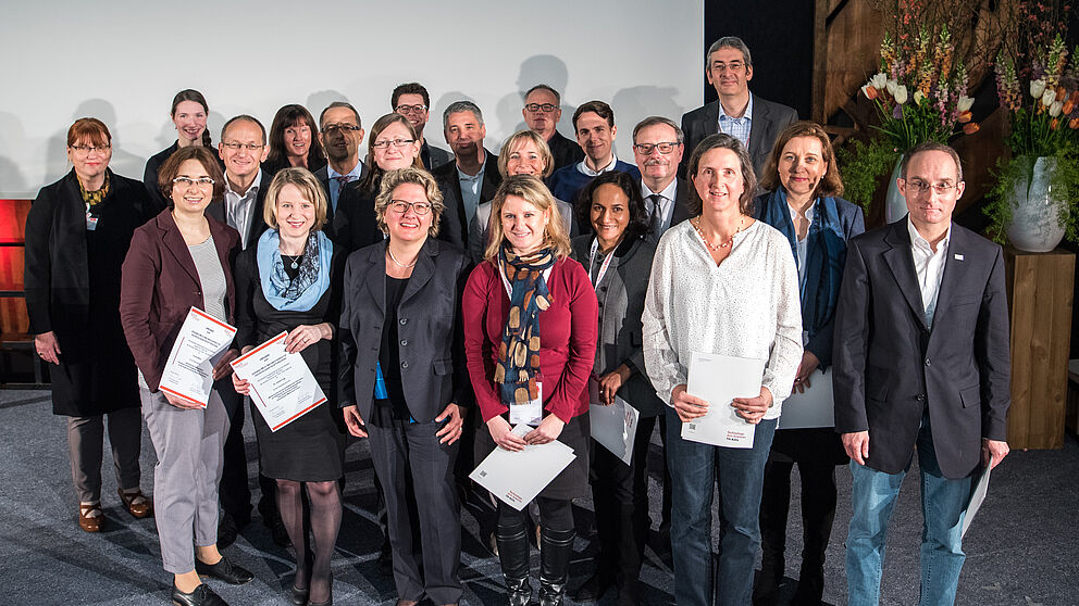 Foto (Costa Belibasakis/TH Köln): Preisübergabe in Anwesenheit von NRW-Wissenschaftsministerin Svenja Schulze, 1. Reihe, 3. von links, links daneben Juliane Fuge. 2. Reihe, 2. von links: Prof. Dr. Niclas Schaper (Vorstandsmitglied der dghd).