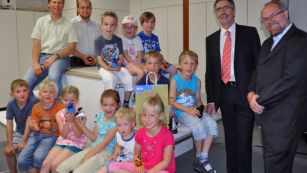Foto: Die Kinder des katholischen Kindergartens St. Johannes der Täufer auf dem useTable mit Holger Fischer und Helge Jung, Mitarbeiter des c-lab (hinten links), Hans Laven, Vorstandsvorsitzender der Sparkasse Paderborn (2. von rechts), und Prof. Reinhar
