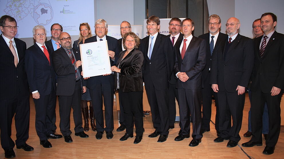 Foto (Referat Presse und Kommunikation, Universität Paderborn, Frauke Döll): NRW-Innovationsministerin Svenja Schulze übergibt Bürgermeister Heinz Paus und den anderen Akteuren und Partnern von FIT.Paderborn das zdi-Gütesiegel.