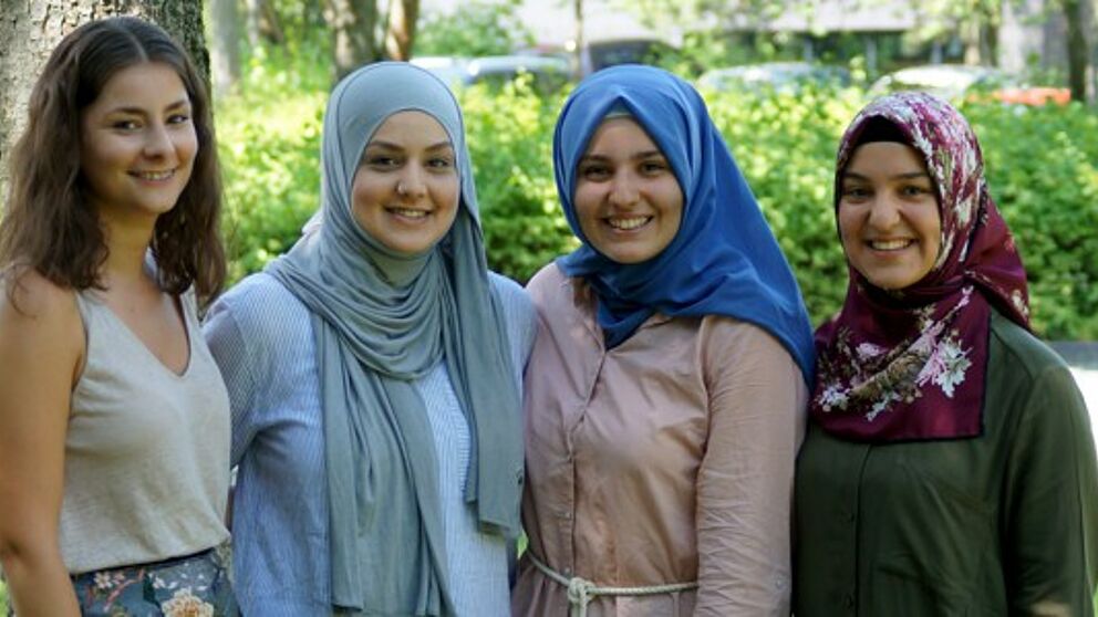 Foto (PLAZ, Björn Heerdegen): Die aktiven Mentorinnen Jana (1. v. l.) und Aysegül (4. v. l.) und ihre zukünftigen Nachfolgerinnen Derya und Sevval (Mitte) ziehen eine positive Bilanz und freuen sich auf kommende Erfahrungen.