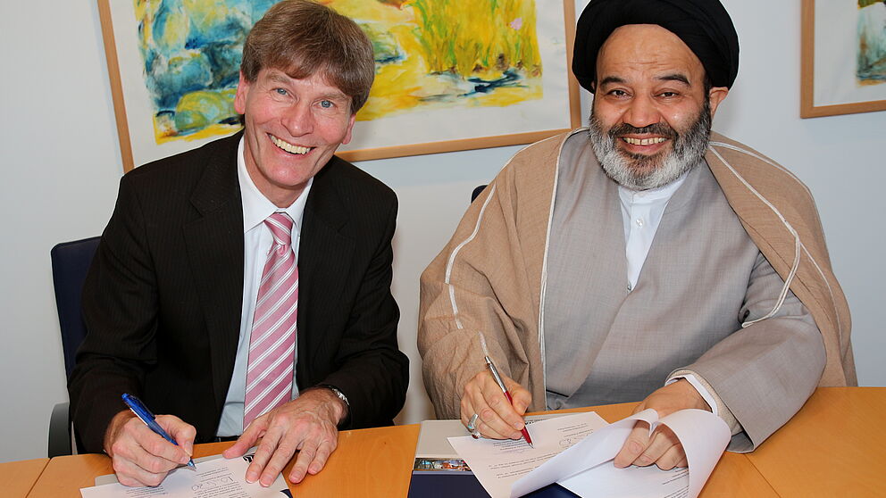 Foto (Universität Paderborn, Patrick Kleibold): Prof. Dr. Nikolaus Risch und Seyed Abdolhassan Navab unterzeichnen die Kooperationsvereinbarung zwischen den beiden Universitäten.