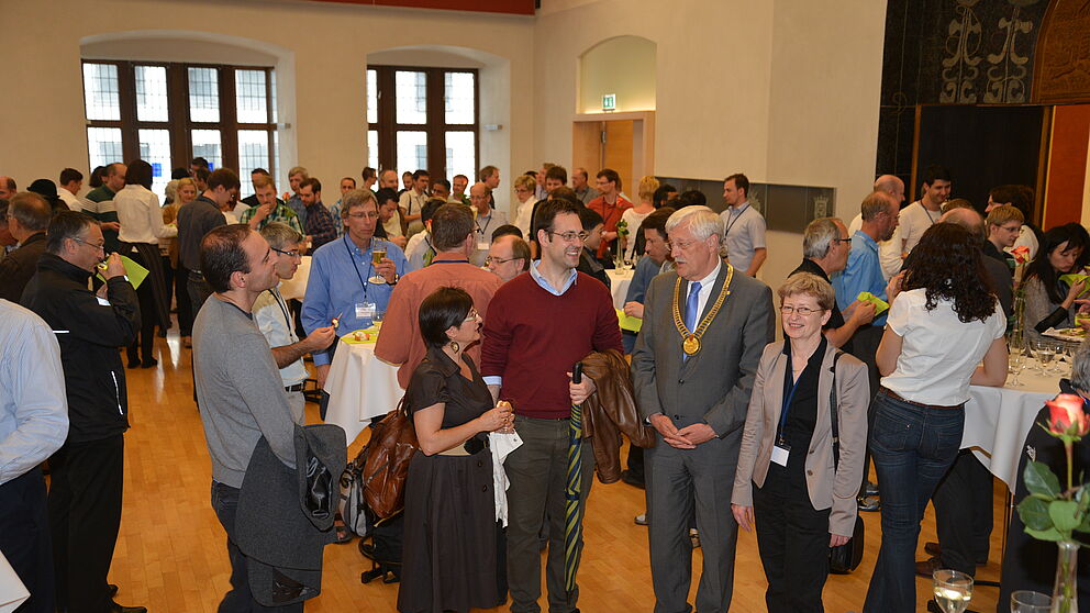 Foto (Stadt Paderborn, Daniel Höing): Bürgermeister Heinz Paus und Prof. Dr. Sybille Hellebrand, Leiterin des diesjährigen IEEE European Test Symposium, im Gespräch mit den Tagungsteilnehmern des diesjährigen „IEEE European Test Symposium" im groß