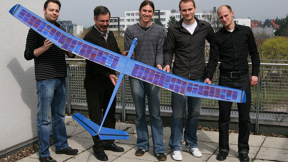 Foto (Universität Paderborn, Fabian Assion): Das Solarflugzeug mit den Elektrotechnik-Studenten André Kleine, Marcel Schönhoff und Bernhard Disselhoff sowie dem Projektinitiator Prof. Dr.-Ing. Ulrich Hilleringmann und dem Betreuer Dipl.-Ing. Benjamin O