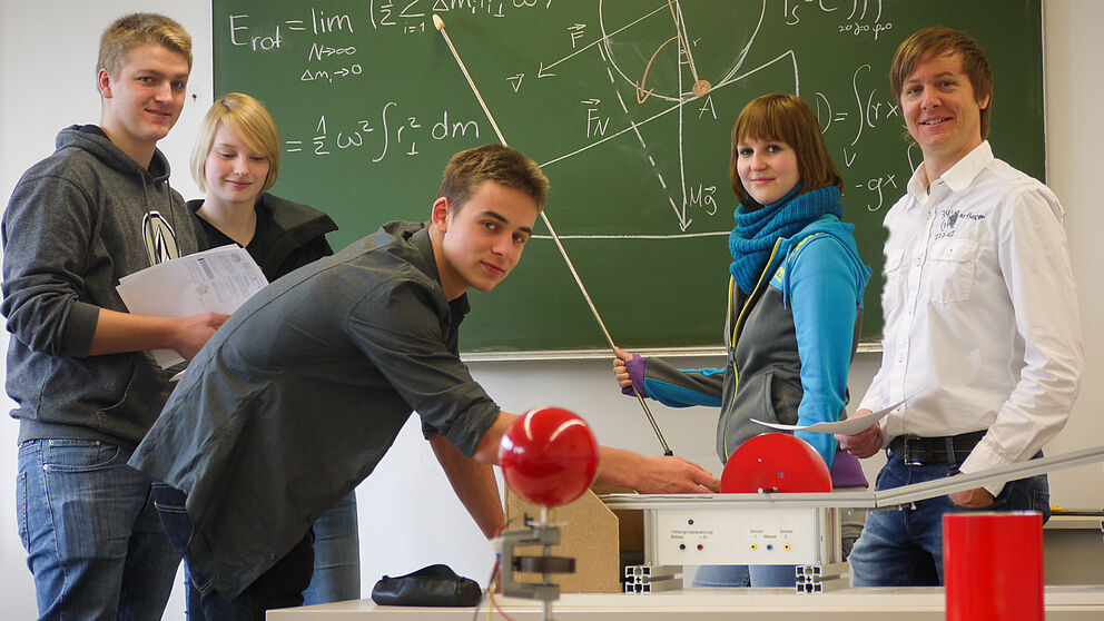 Foto (Department Physik): Physik-Studierende und Dr. Marc Sacher, Studienberater und Leiter des Physikalischen Grundpraktikums, gemeinsam im Labor.