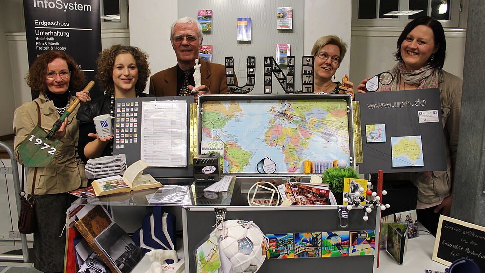 Foto (Universität Paderborn, Heiko Appelbaum): Präsentieren einen der Uni-Museumskoffer (v. l.): Prof. Dr. Jutta Ströter-Bender, Sabrina Zimmermann, Prof. Dr. Steffen Gronemeyer, Gisela Grumpe-Aßmann (Stadtbibliothek Paderborn) und Corinna Pott.