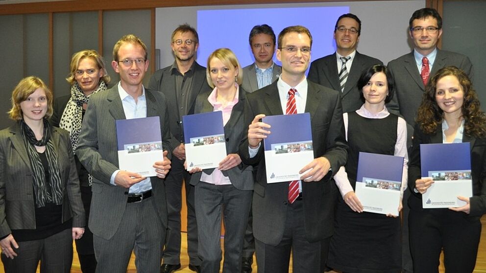 Foto (Universität Paderborn, Mark Heinemann): Herausragend: Die fünf Preisträger Nicolai Bohn (3.v.l.), Jenny Bartuli (m.), Dr. Christian Deutscher (5.v.r.), Erika Fladung (3.v.r.) sowie Natasa Bilkic (r.) wurden von der Unternehmergruppe Ostwestfalen 