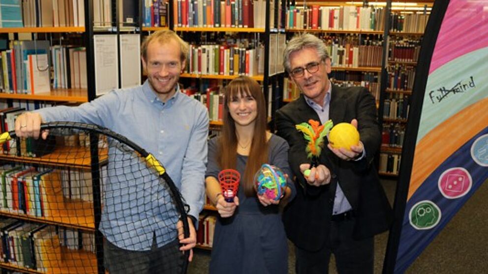 Foto (Heiko Appelbaum): Dennis Fergland, Cornelia Raetze und Dr. Dietmar Haubfleisch (v. l.) werben für bewegte Pausen in der Universitätsbibliothek Paderborn.