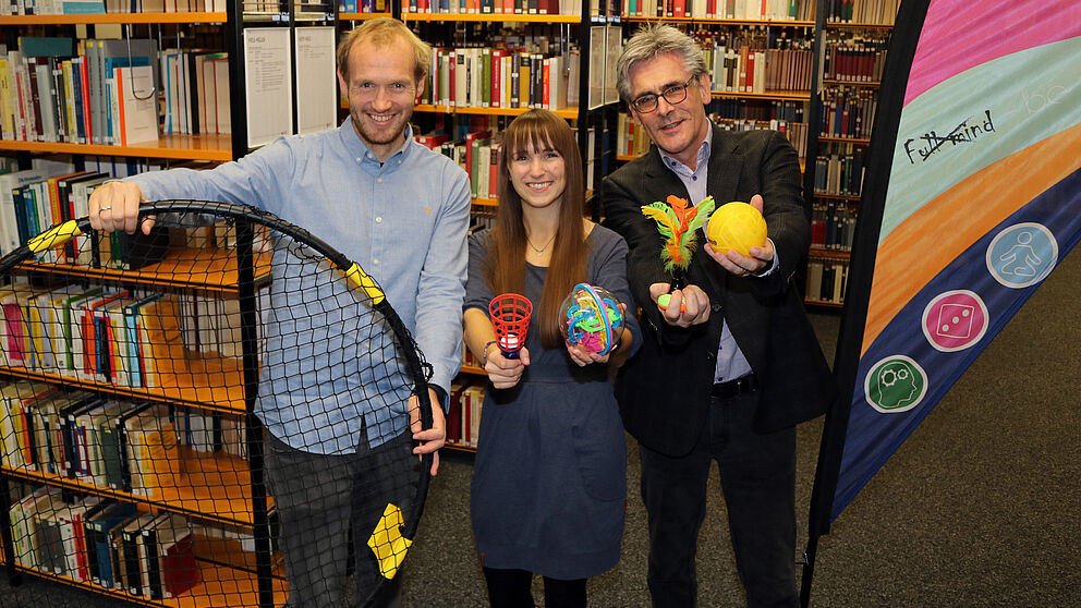 Foto (Heiko Appelbaum): Dennis Fergland, Cornelia Raetze und Dr. Dietmar Haubfleisch (v. l.) werben für bewegte Pausen in der Universitätsbibliothek Paderborn.