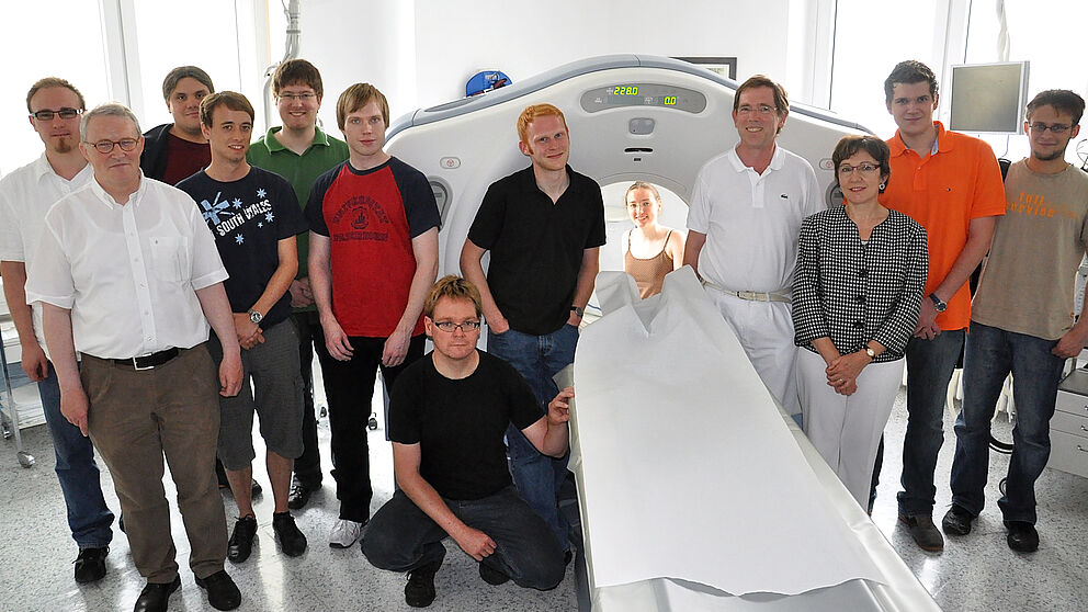 Foto (Universität Paderborn, Simon Beisel): Informatikstudierende, Dr. med. Wolfgang Krings (4. v. r.), Prof. Dr. Gitta Domik (3. v. r.) und Dipl.-Ing. Norbert Linnebank, Leiter der technischen Abteilung (2. v. l) vor dem CT-Gerät der radiologischen Abt