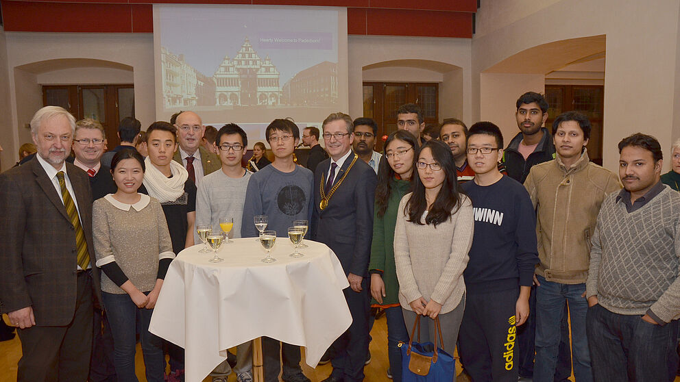Foto (Stadt Paderborn): Die ausländischen Studierenden im Paderborner Rathaus begrüßten Bürgermeister Michael Dreier (Mitte) und Uni-Vizepräsident Wilhelm Schäfer (links).
