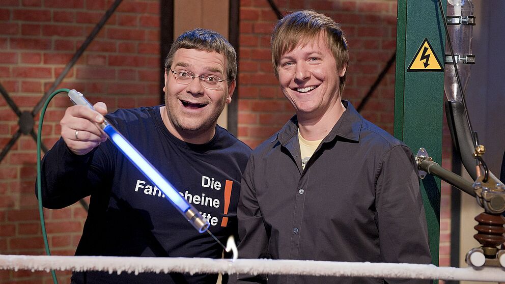 Foto (ZDF/Ralf Wilschewski): (v.l.n.r.): Moderator Elton und Dr. Marc Sacher vor der vereisten Oberleitung.