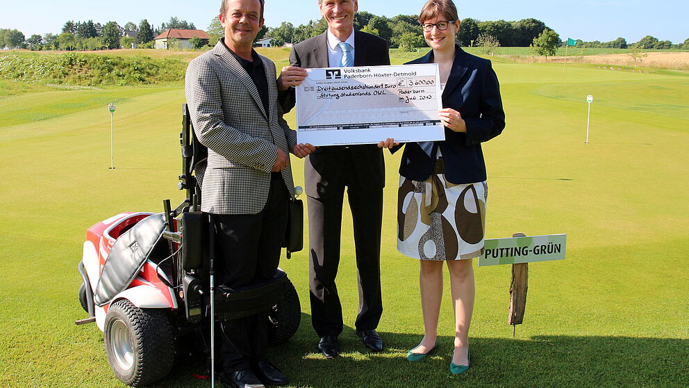 Foto (Universität Paderborn, Vanessa Dreibrodt): (v. l.) Freuen sich über die Spenden der Turnierteilnehmer: Helmut Böhmer, Geschäftsführer Haxterpark im Powergolfer, Prof. Dr. Nikolaus Risch, Präsident der Universität Paderborn, und Friederike Ruw