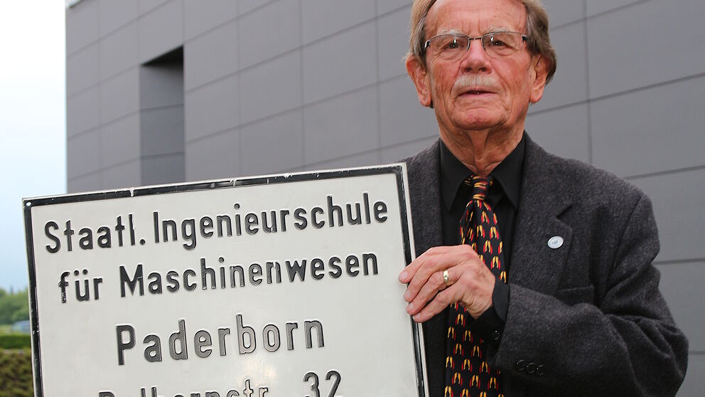 Foto (Universität Paderborn, Vanessa Dreibrodt): Ein Stück Uni-Geschichte: Prof. Dr. Lothar Weeser-Krell schenkt das alte Schild der Staatlichen Ingenieursschule für Maschinenwesen dem Universitätsarchiv.