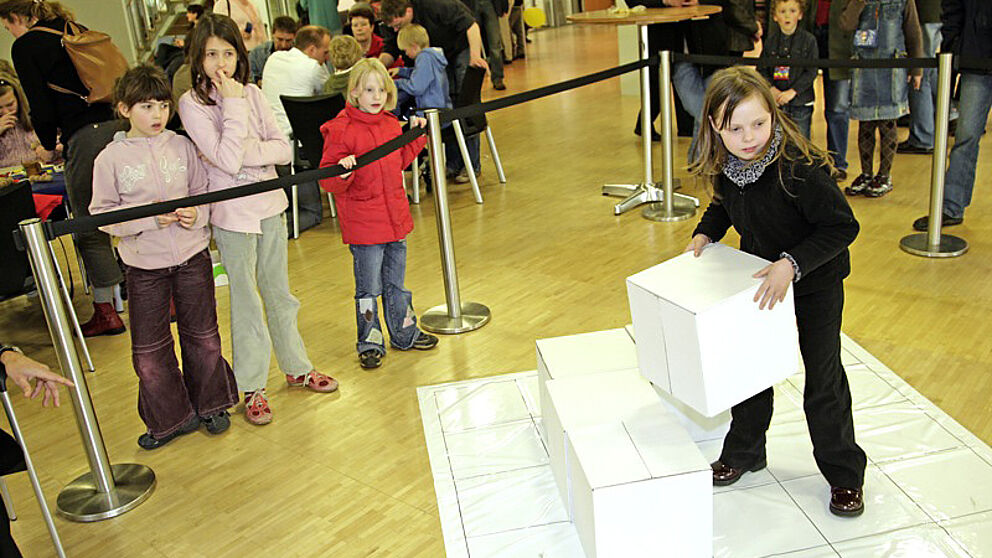 Foto (Jan Braun, HNF): „Auf die Würfel, fertig los!“ – Eine begeisterte Teilnehmerin in der Startposition zum PotzKlotzwettbewerb der Universität Paderborn