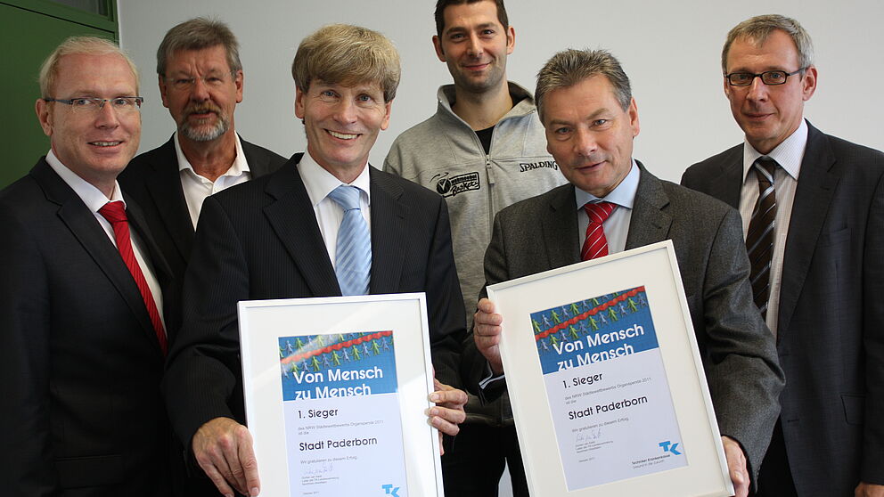 Foto (Universität Paderborn, Patrick Kleibold): Zur Übergabe der Urkunden waren anwesend: Karl-Julius Sänger (TK) (v.l.), Dieter Thiele (Leiter Hochschulsport), Prof. Dr. Nikolaus Risch (Präsident der Uni Paderborn), Daniel Lieneke (Paderborner Basket