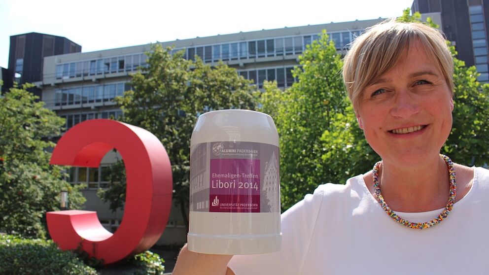 Foto (Universität Paderborn, Frauke Döll): Das Sommerwetter ist bestellt, der Alumni-Krug fertig: Alexandra Dickhoff von Alumni Paderborn lädt ein zum Ehemaligen-Treff am Libori-Freitag.