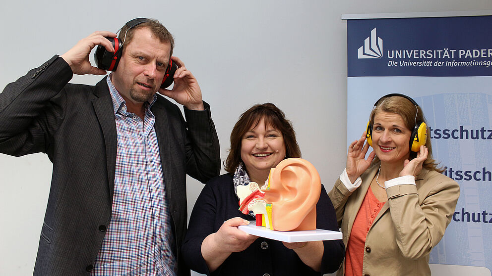 Foto (Universität Paderborn, Heiko Appelbaum): Laden zum Tag gegen den Lärm in die Universität Paderborn (v. l.): Martin Hohrath, Sylvia Moore und Diana Riedel.
