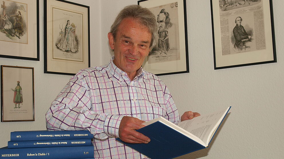 Foto (Universität Paderborn, Martin Decking): Dr. Wolfgang Kühnhold freut sich über das Erscheinen der siebenbändigen Werkausgabe der Meyerbeer Oper „Robert der Teufel“.