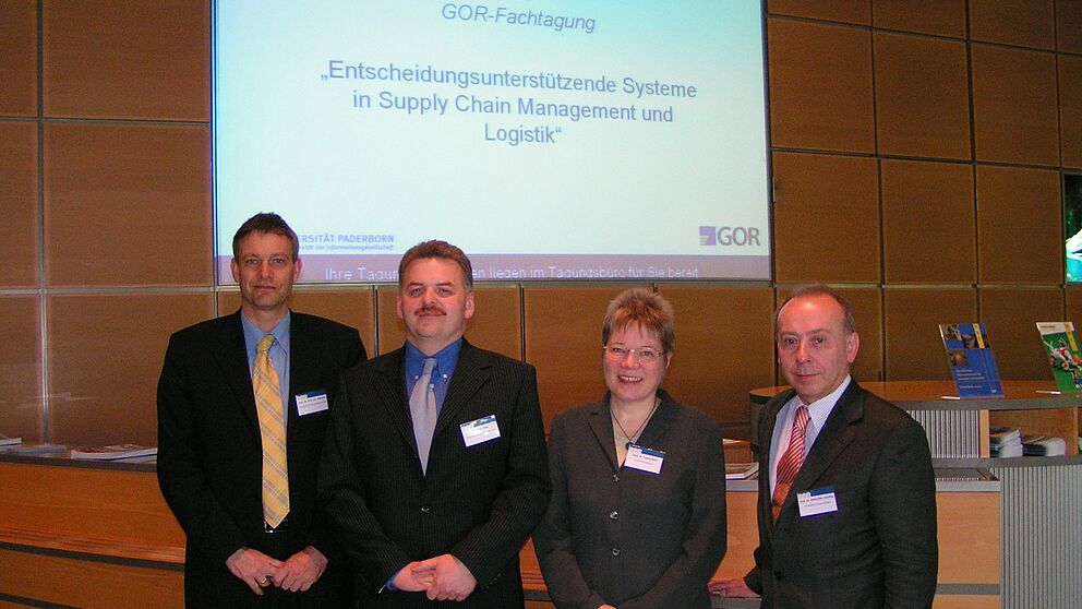 Foto: Die Leiter der GOR-Arbeitsgruppen freuten sich, den Gastredner Dr. Dieter Pütz vom Deutschen Post World Net begrüßen zu dürfen (v.l.: Prof. Dr. Dirk Mattfeld, Dr. Dieter Pütz, Prof. Dr. Leena Suhl, Prof. Dr. Hans-Otto Günther)