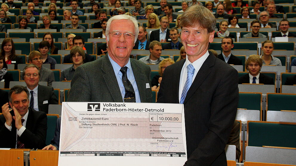 Foto (Universität Paderborn, Patrick Kleibold): Der Vorsitzende der Universitätsgesellschaft Paderborn, Prof. Dr. Steffen Gronemeyer (links), überreichte den Scheck in Höhe von 10.000 Euro an Prof. Dr. Nikolaus Risch, Vorstandvorsitzender der Stiftung