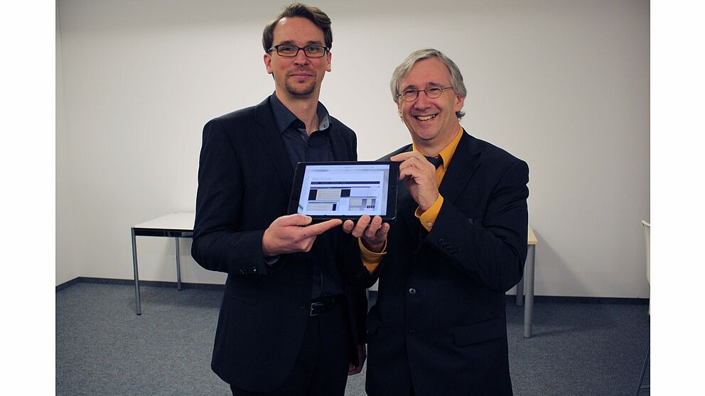 Foto (Musikhochschule Detmold, Friedrich von Plettenberg): Zukünftig werden Musiker vom Tablet spielen anstatt vom Blatt: Dipl. Wirt.-Inf. Daniel Röwenstrunk (l.) und Prof. Dr. Joachim Veit (r.) vom Kompetenzzentrum "Musik-Edition-Medien" präsentieren 