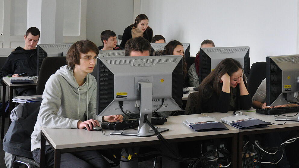Foto: (Universität Paderborn, Isabel Stroschein): Die Schülerinnen und Schüler der Friedrich-von-Spee-Gesamtschule bei der vertiefenden Gruppenarbeit unter der Anleitung von Kathlén Kohn (hinten rechts).