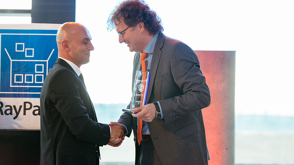 Foto (Universität Paderborn, TecUP): Prof. Dr. Rüdiger Kabst vom Technologietransfer- und Existenzgründungs-Center der Universität Paderborn, TecUP, (r.) überreichte die Auszeichnung an Unternehmensgründer Ragip Aydin (l.).