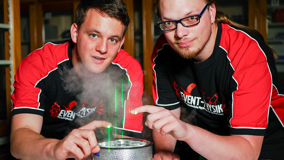 Foto (Universität Paderborn, Johannes Pauly):  Die Event-Physiker Carsten Müller (li.) und Tim Eichelberger testen Laser für den Aufbau einer großen Laserharfe. 