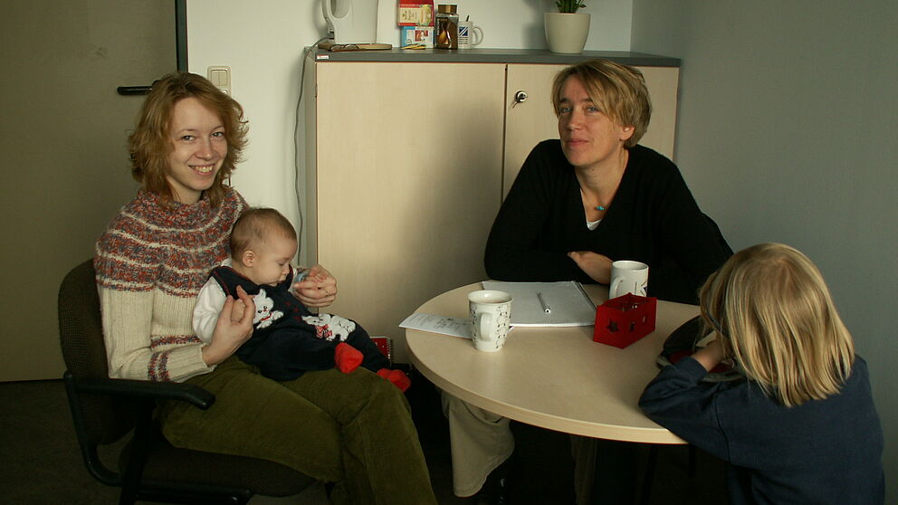 Foto (v. re.): Barbara Pickhardt vom Eltern-Service-Büro der Universität Paderborn im Beratungsgespräch mit der wissenschaftlichen Mitarbeiterin Sandra Boedeker. Mit von der Partie: Anais und Noah.