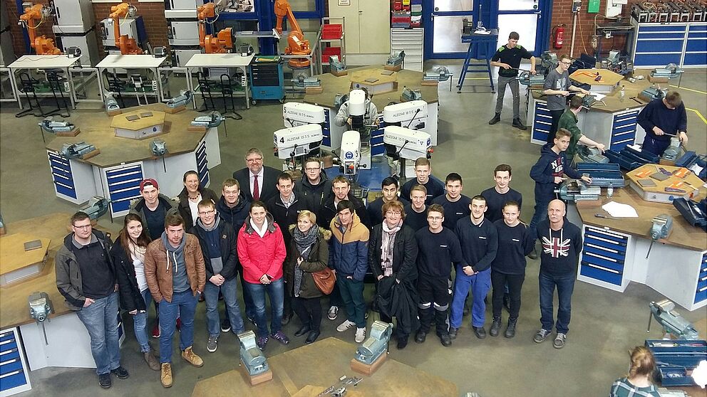 Foto (Universität Paderborn,  Fachgebiet Technikdidaktik): Lehramtsstudierende der Universität Paderborn und Auszubildende im Aus- und Weiterbildungszentrum der Firma Benteler, begleitet von Prof. Katrin Temmen (letzte Reihe, 2. v. l.) und Ausbildungsle
