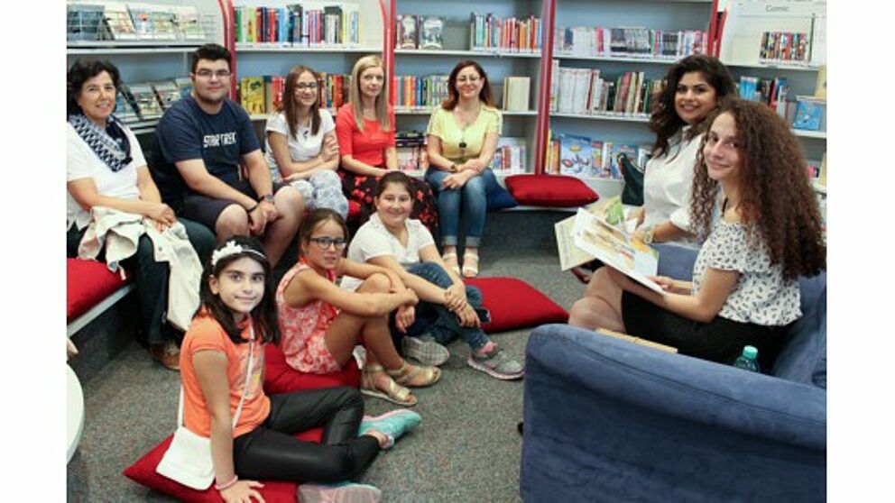 Foto (Universität Paderborn, Ricarda Michels): Hala Alkhatib und Meryem Düzel (Erste und Zweite v. r.) lasen Kindern und Eltern in der Paderborner Kinderbibliothek auf Arabisch, Deutsch und Türkisch vor.