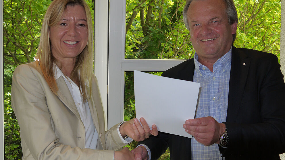 Foto: Manfred Gubitz überreicht den Forschungspreis 2013 der Stiftung der Dienstleistungsgruppe Salzkotten (DGS-Stiftung) an Dr. Maria Marchwacka.
